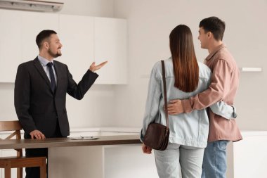 Emlakçı çiftlere mutfağı gösteriyor.