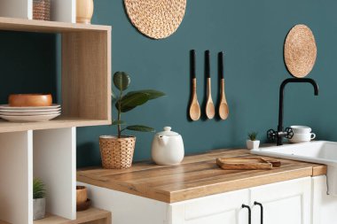 Mutfağın içinde mavi duvarın yanında lavabo var.