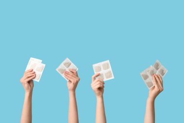 Mavi arka planda hardal sıva olan kadın elleri.