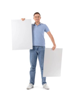 Beyaz arka planda boş posterleri olan yakışıklı bir genç.