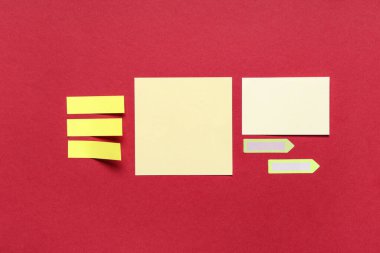 Kırmızı arkaplanda farklı boş yapışkan notlar