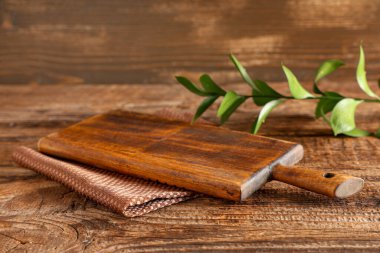 Tahta üzerinde peçete ve ruskus yaprakları olan boş kesim tahtası