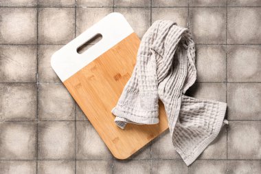 Gri kartonlu masa üzerinde peçeteyle kesme tahtası, üst görünüm