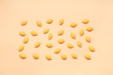 Bej arka planda pişmemiş makarna kabukları