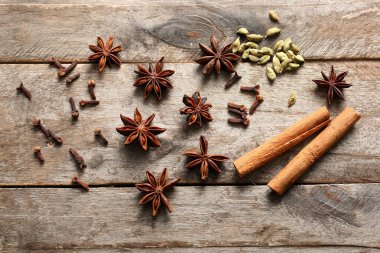 Tohumları, karanfilleri ve ahşap arka planda tarçın olan anason yıldızları