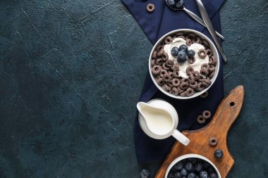 Mısır gevreği halkalı kase ve mavi grunge arka planda süt