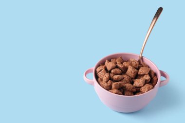 Mavi arka planda lezzetli çikolatalı mısır yastıkları olan bir kase.