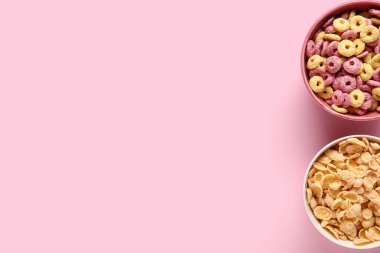 Pembe arka planda sağlıklı mısır gevrekleri olan kaseler