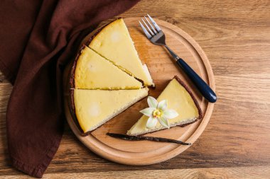 Tahta zemin üzerinde tatlı vanilyalı cheesecake parçaları olan tahta.