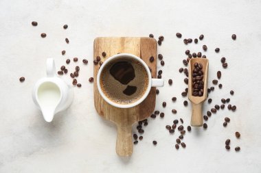 Fasulyeli sıcak kahve ve beyaz arka planda bir sürahi taze süt.