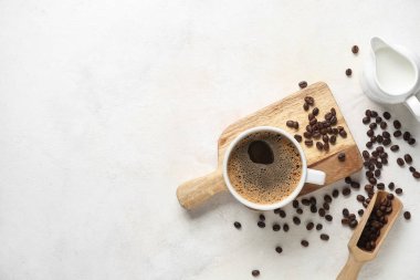 Fasulyeli sıcak kahve ve beyaz arka planda bir sürahi taze süt.