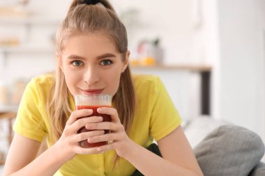 Mutfakta sebze suyu içen genç bir kadın, yakın plan.