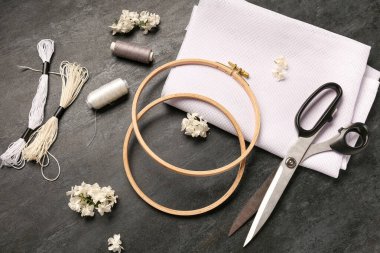 Tuval işlemeli halkalar, küflü iplikler ve grunge siyah arka planda makas.