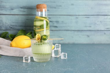 Mavi masada salatalıklı bir şişe limonata.