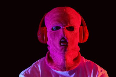 Siyah arka planda kulaklıkları olan kar maskeli yakışıklı bir genç.