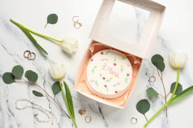 Tatlı bento keki, güzel laleler ve beyaz arka planda mücevherlerle dolu bir kutu. Uluslararası Kadınlar Günü