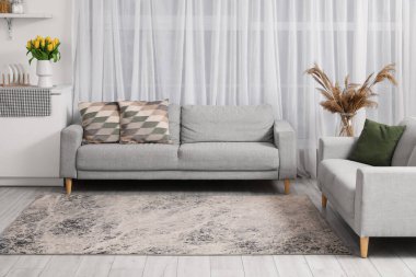 Pencerenin yanında yumuşak kanepesi olan rahat oturma odası.