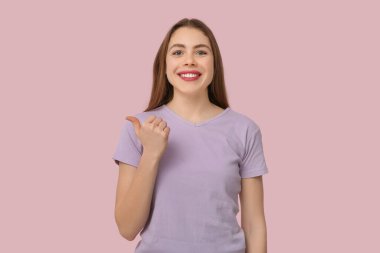 Young deaf mute woman using sign language on pink background