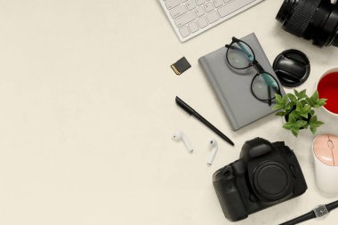Profesyonel fotoğrafçı ekipmanları, modern cihazlar ve arka planda kırtasiye malzemeleriyle kompozisyon