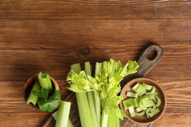 Ahşap zemin üzerinde taze yeşil kereviz olan yemek ve kaseler.