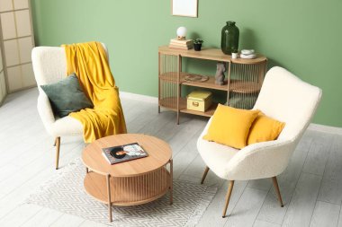 Rahat koltukları, kahve masası ve sarı ekoseli oturma odasının güzel iç mekanı.