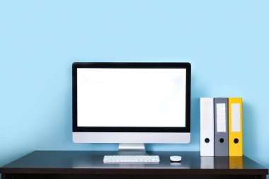 Ofisinde klasörleri ve modern bilgisayarı olan şık bir iş yeri