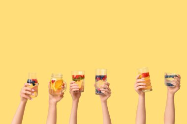 Sarı zemin üzerinde aşılanmış su olan birçok el