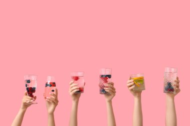 Pembe arka planda erimiş su olan birçok el