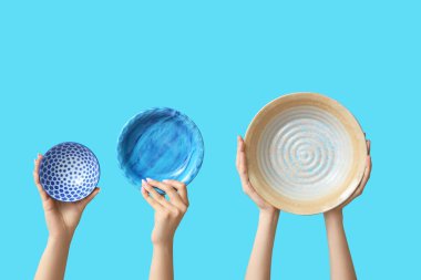 Mavi arkaplanda boş tabakları tutan eller