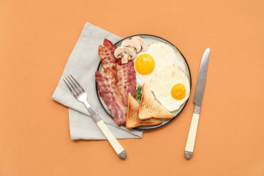 Lezzetli kızarmış yumurta, kızarmış ekmek ve bej arka planda pastırma. Üst görünüm