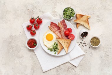 Lezzetli sahanda yumurta, pastırma, tost, domates ve beyaz grunge arka planda baharatlar. Üst görünüm