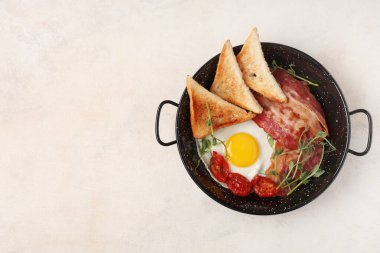 Kızarmış yumurta, pastırma, kızarmış ekmek ve domatesli beyaz arka plan. Üst görünüm