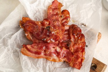 Beyaz arka planda kızarmış pastırmalı ahşap döküntü ve biberli, yakın plan.