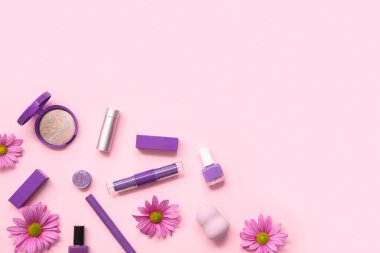 Makyaj ürünleri, oje ve pembe arka planda çiçekler.