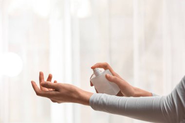 Kadın eli evde parfüm sıkıyor.