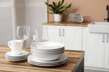 Mutfaktaki ahşap masada temiz tabaklar.