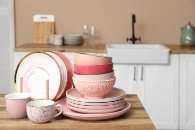 Mutfaktaki ahşap masada temiz pembe tabaklar.