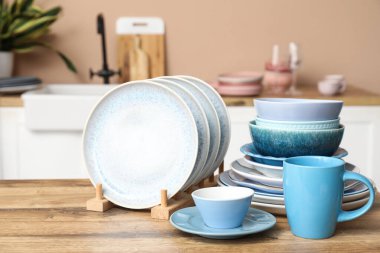 Mutfaktaki ahşap masada temiz mavi tabaklar.