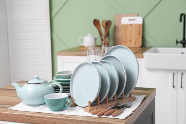 Mutfaktaki ahşap masada temiz mavi tabaklar.