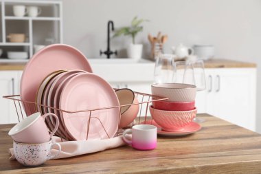 Mutfak tezgahında temiz pembe tabakları olan bir tutucu.
