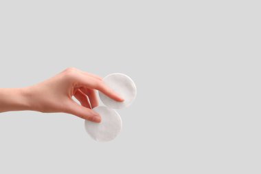 Beyaz arka planda pamuk pedleri tutan kadın.