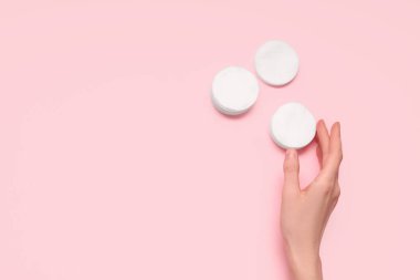 Pembe arka planda pamuk pedleri olan bir kadın.