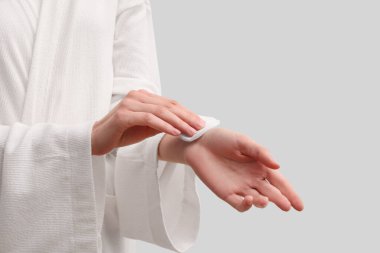 Beyaz duvarın yanında pamuk yastıklı genç bir kadın