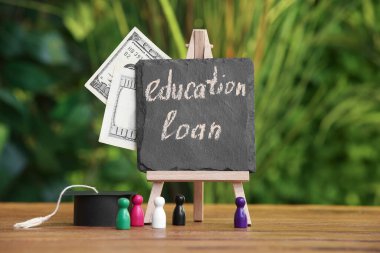 Yazı tahtası, yazı tahtasından kredi, para, mezuniyet şapkası ve açık masa rakamları.