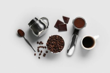 Fasulyeli bir fincan sıcak kahve, tatlı çikolata ve gri arkaplanda toz filtresi.