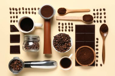 Tatlı çikolatalı bir fincan sıcak kahve ve sarı arka planda fasulye ve pudra.