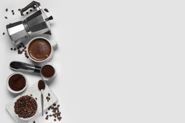 Beyaz arka planda fincanlı gayzer kahve makinesi, portafilter ve fasulye.