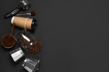 Geyser kahve makinesi, paket kâğıt bardakları, portatif filtresi ve siyah arka planda fasulye.