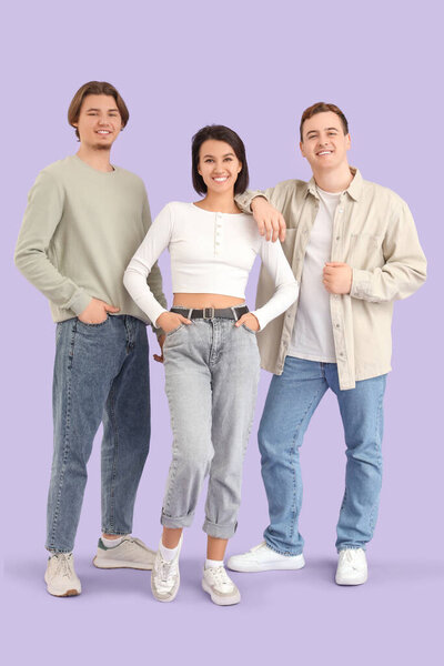 Young people in jeans on lilac background