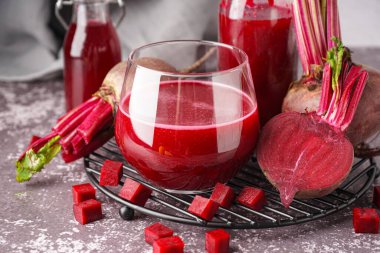 Masada bir bardak taze pancar suyu ve sebze.